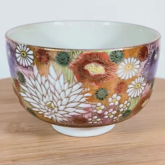 Vidéo sur plateau tournant montrant un bol à thé japonais Kutani signé Seishō (星昭), rotation complète pour présenter le décor floral.