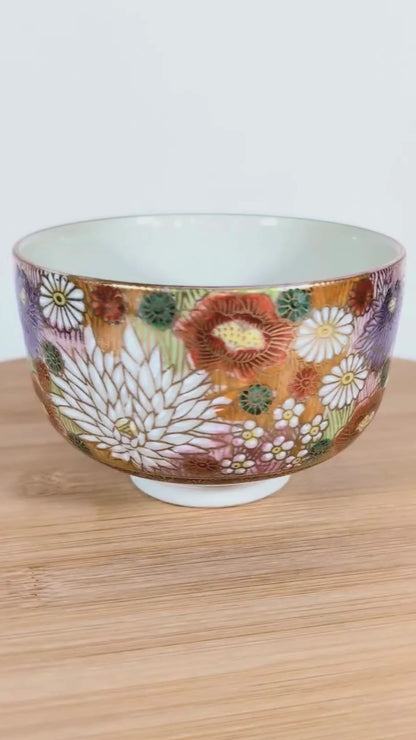 Vidéo sur plateau tournant montrant un bol à thé japonais Kutani signé Seishō (星昭), rotation complète pour présenter le décor floral.