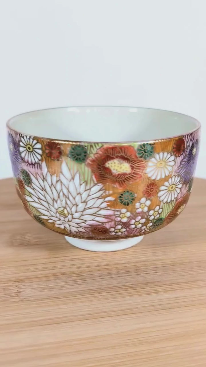 Vidéo sur plateau tournant montrant un bol à thé japonais Kutani signé Seishō (星昭), rotation complète pour présenter le décor floral.