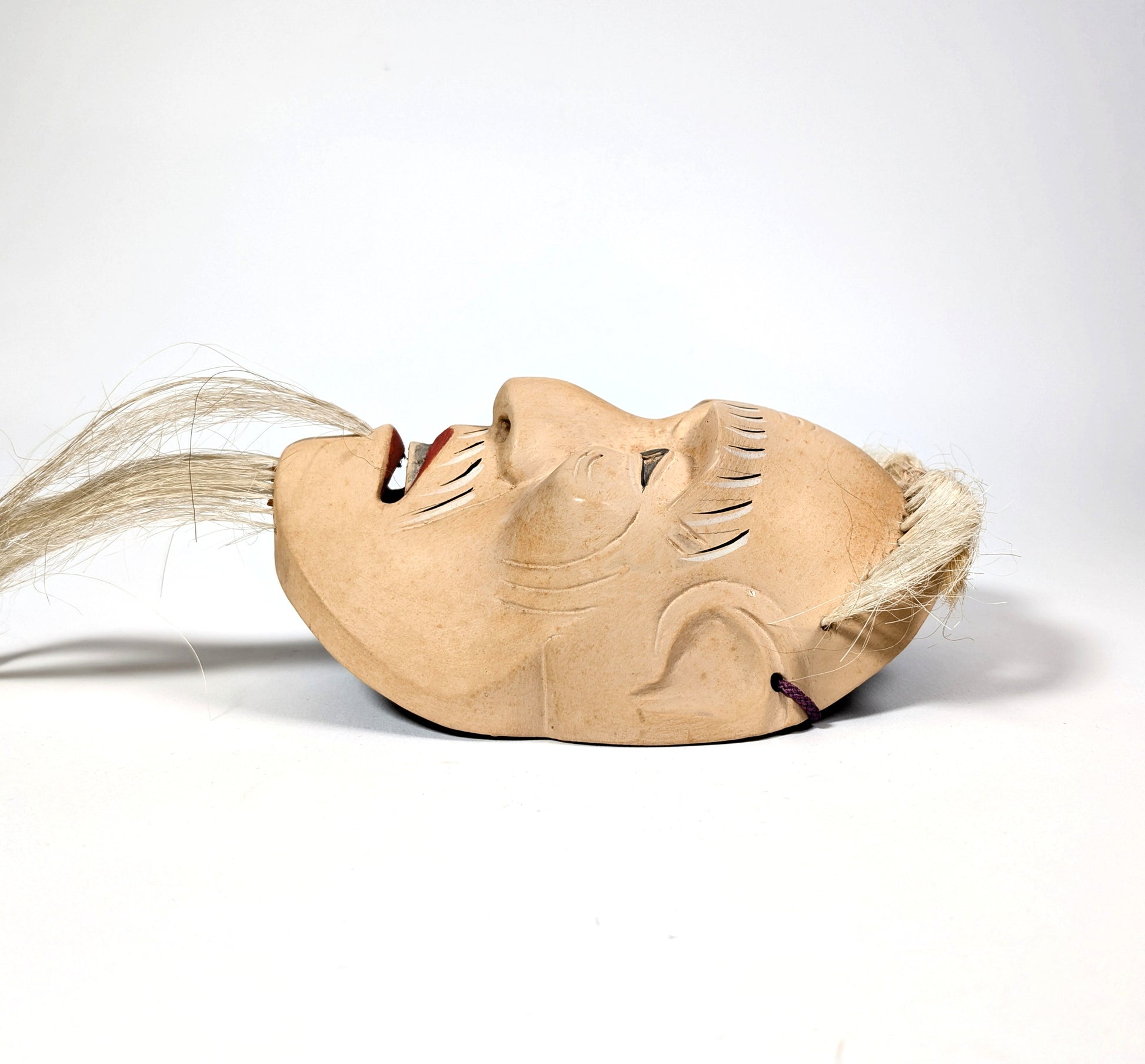 Profil gauche du masque de Nô japonais Kōshi-jō, représentant un vieillard sculpté dans la tradition artisanale japonaise.