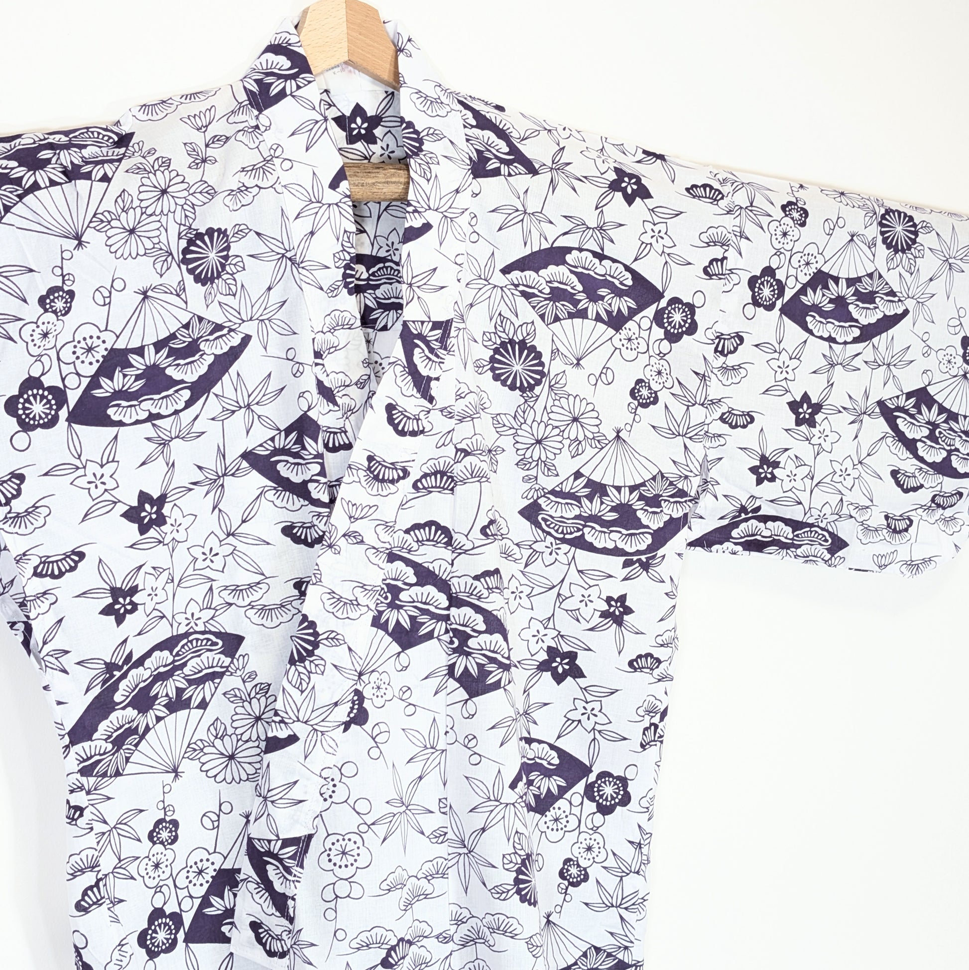Robe d’intérieur japonaise en coton blanc, détail du col croisé avec motifs sensu, kikyō, ume et feuillages japonais violets