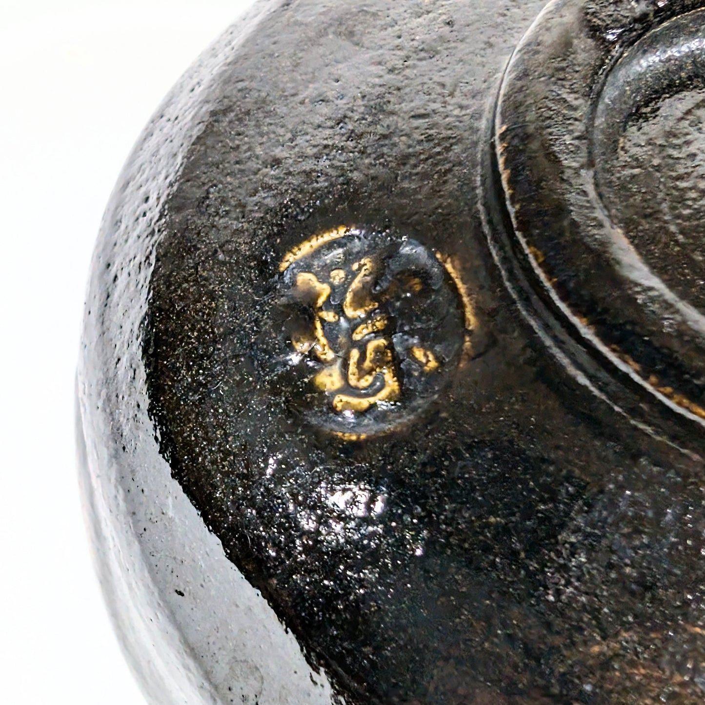 Sceau du potier Sasaki Shoraku apposé sous un chawan en raku noir japonais.