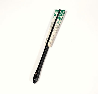 Éventail japonais sensu fermé avec décor d’érables verts, papier ivoire et monture noire laquée.
