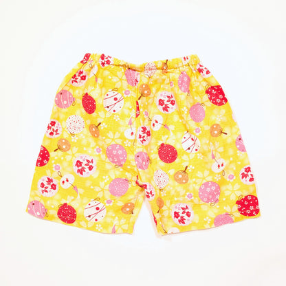 Short de jinbei enfant en coton jaune, décor de matsuri japonais avec fūrin, uchiwa et ballons d’eau.