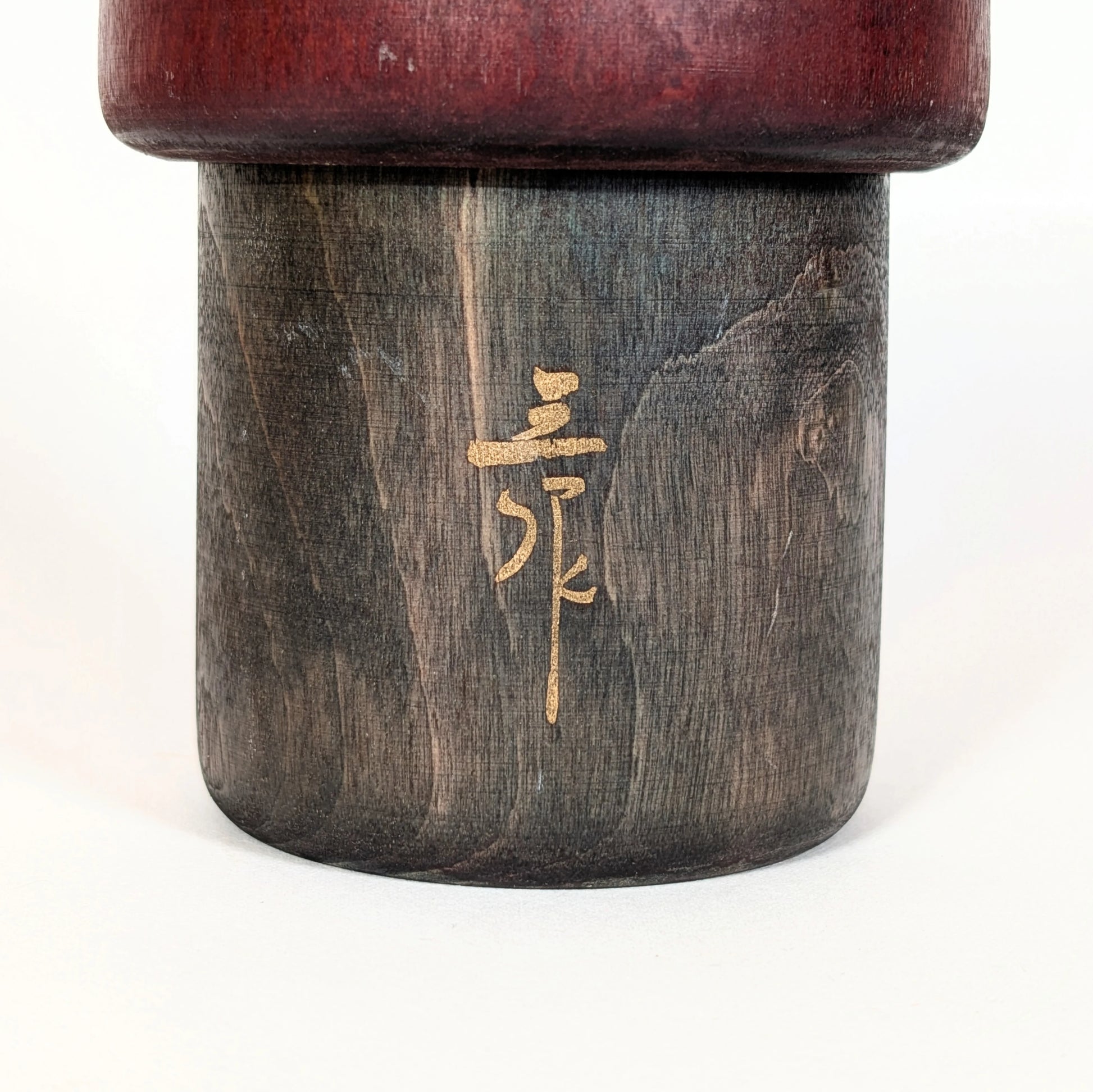 Détail de la signature calligraphiée de l’artiste japonais Sansaku Sekiguchi sur une poupée kokeshi sōsaku