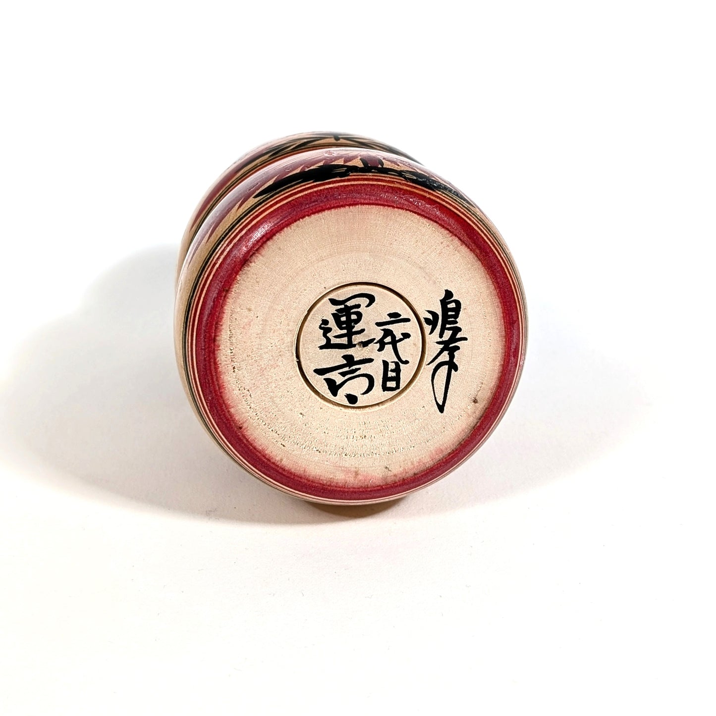 Signature manuscrite sous une kokeshi Naruko ancienne, artisan japonais Unkichi