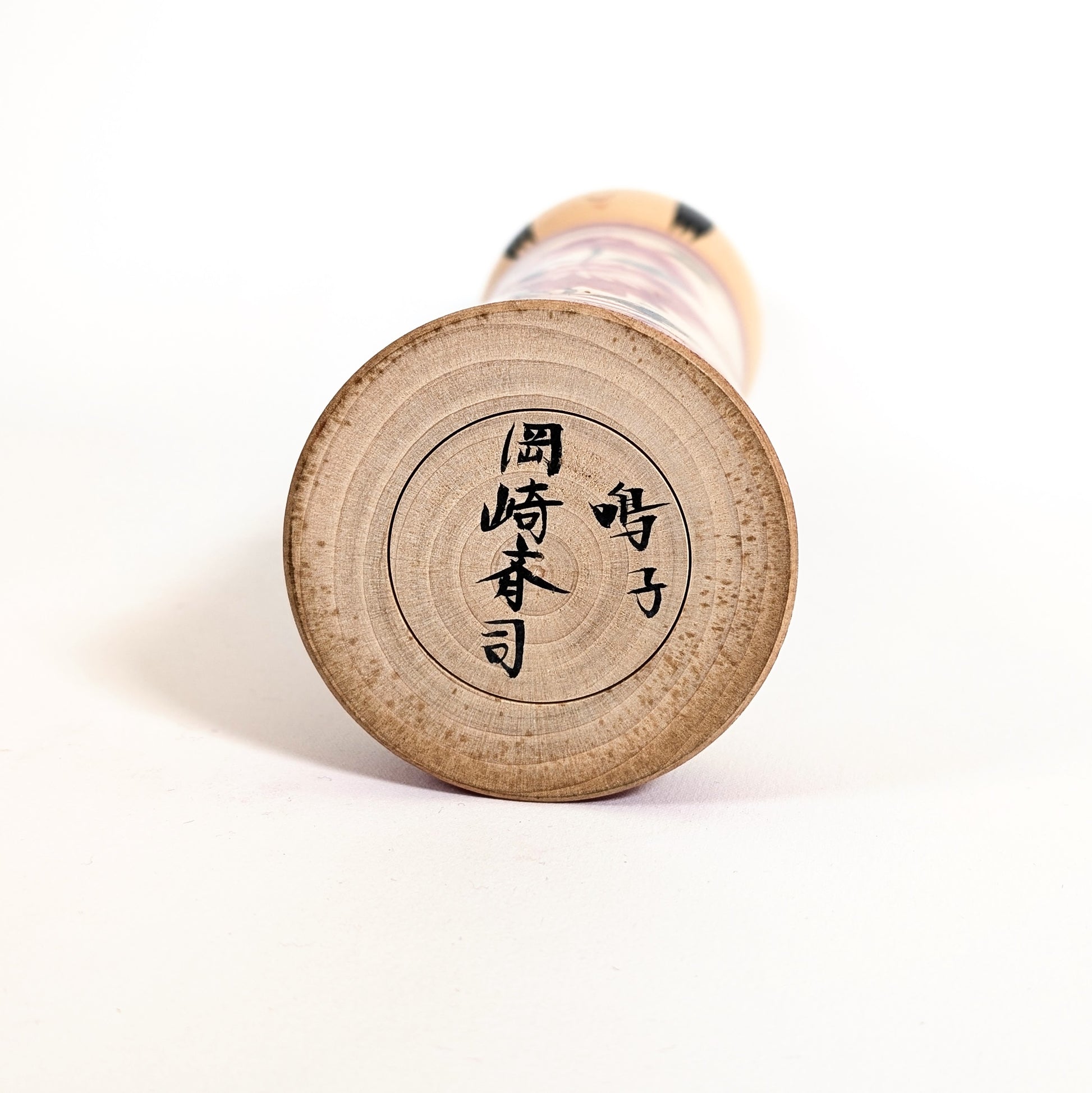 Signature japonaise 岡崎斉司 sous une poupée japonaise kokeshi Naruko ancienne