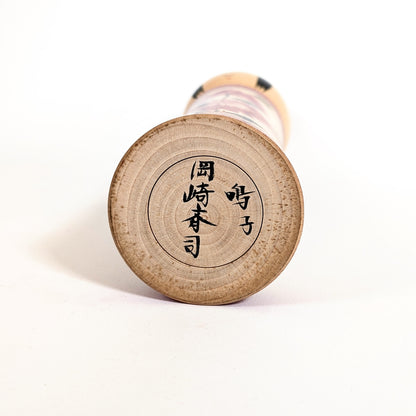 Signature japonaise 岡崎斉司 sous une poupée japonaise kokeshi Naruko ancienne