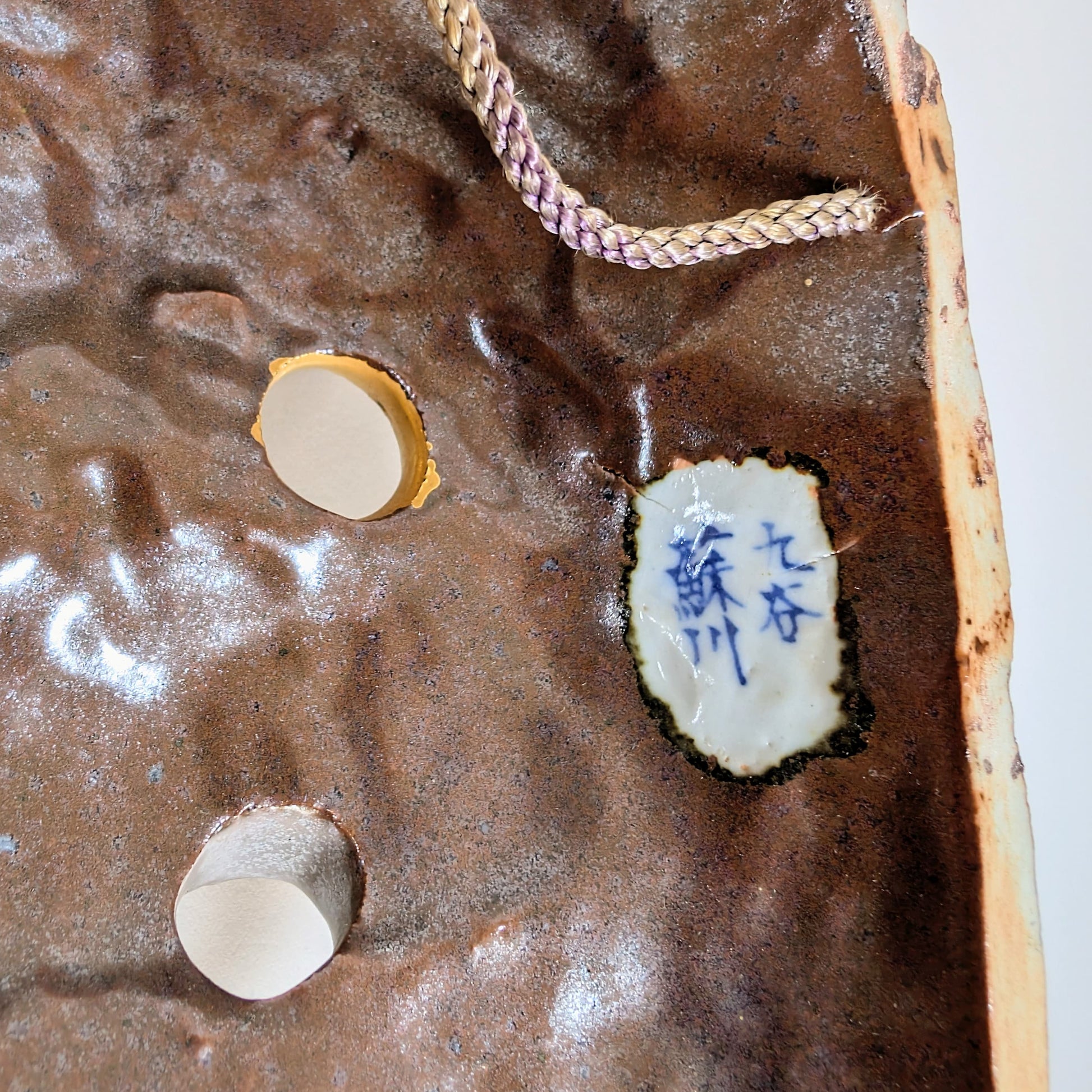 Signature de Matsuda Sokawa à l’intérieur d’un masque Nô en céramique Kutani représentant Susanoo no Mikoto