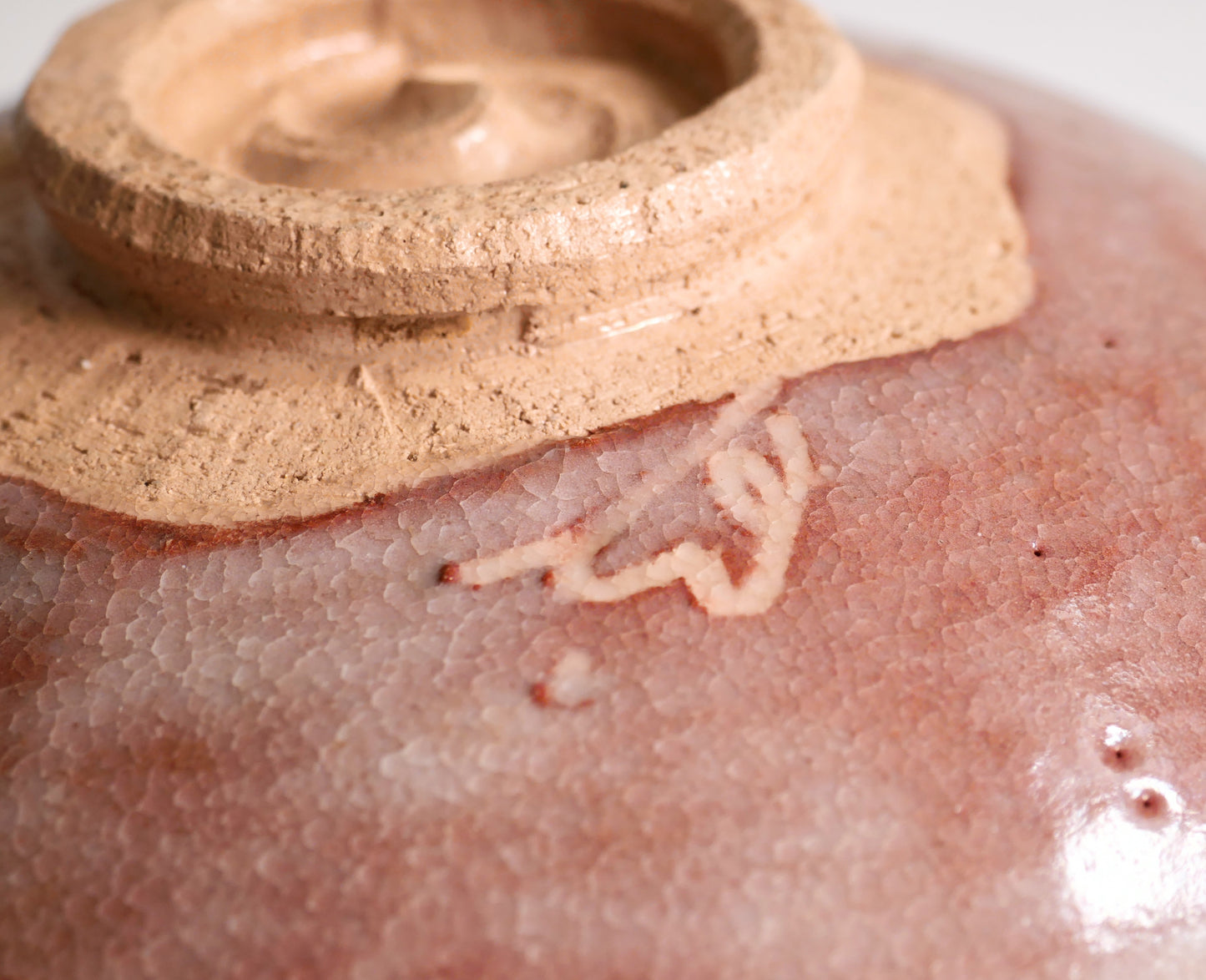 Signature du potier près du pied kōdai spiralé d’un bol raku japonais avec glaçure kanyū