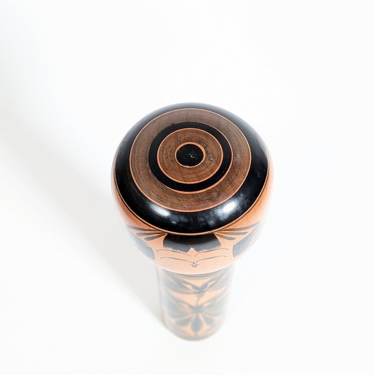 dessus d'une kokeshi japonaise shingata en bois tourné avec motif janome oeil de serpent. Artisanat traditionnel japonais