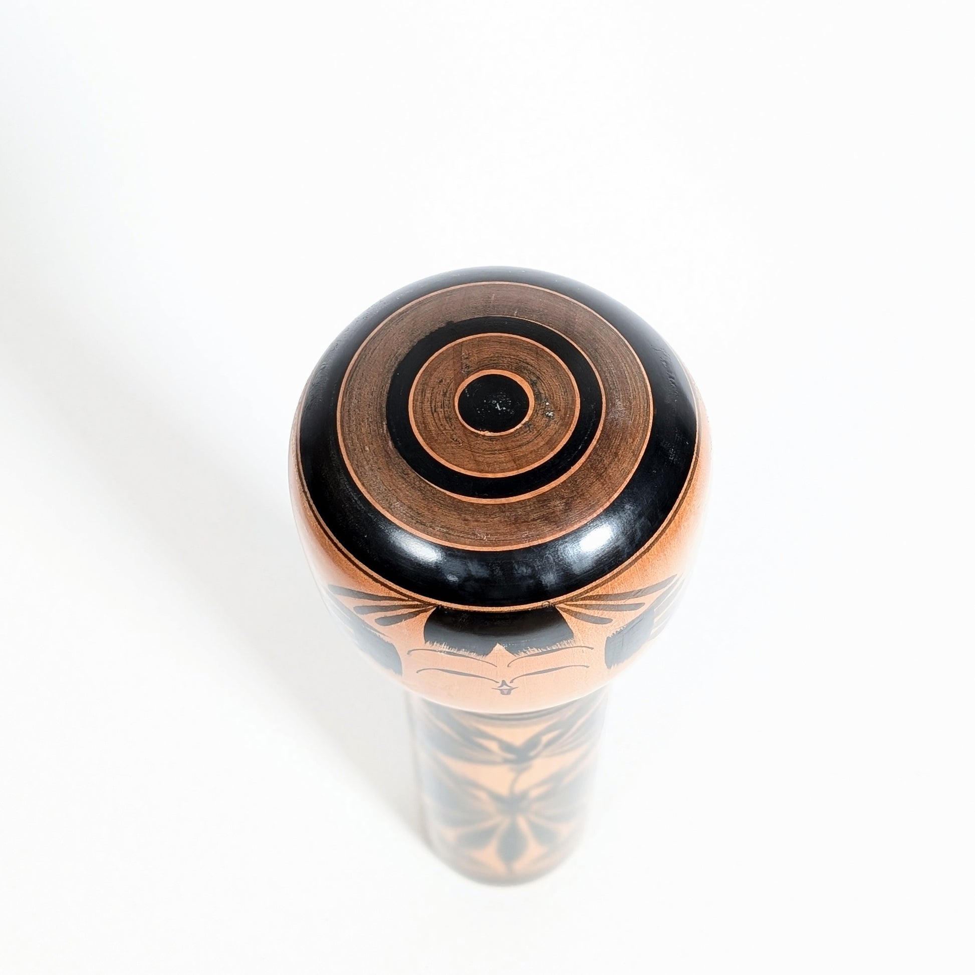 dessus d'une kokeshi japonaise shingata en bois tourné avec motif janome oeil de serpent. Artisanat traditionnel japonais