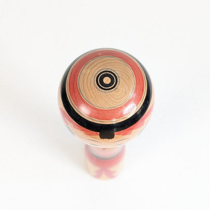 Vue du sommet d’une kokeshi Yajiro avec décor circulaire concentrique évoquant un motif janome peint au tour