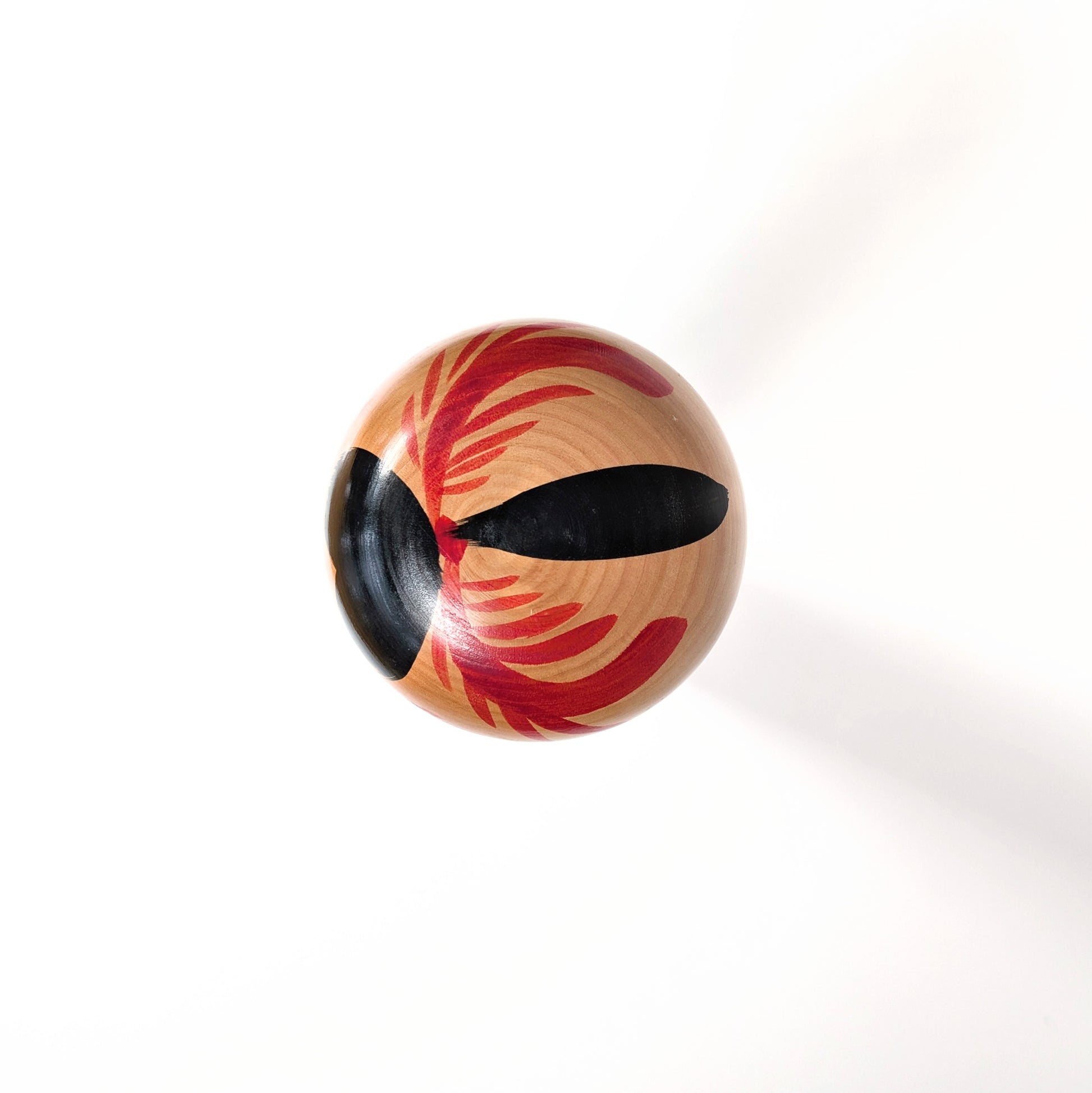 Vue du dessus de la tête d’une kokeshi Sakunami avec décor peint géométrique traditionnel