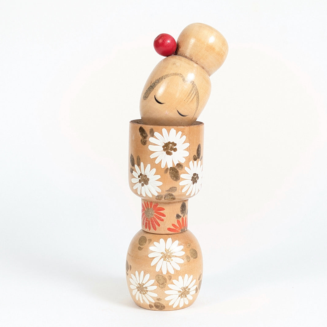Sosaku kokeshi d’Ishida Tomio vue de face, décor de chrysanthèmes blancs et orange aux détails dorés.