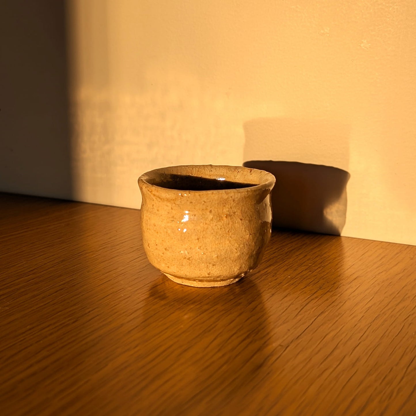 Tasse à saké japonaise en Hagi-yaki, ochoko wabi-sabi photographié en lumière naturelle chaleureuse