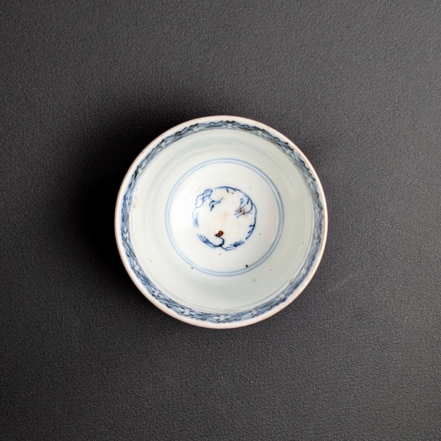 Vue intérieure de tasse à thé japonaise ancienne, décor bleu sometsuke au fond et frise au bord.
