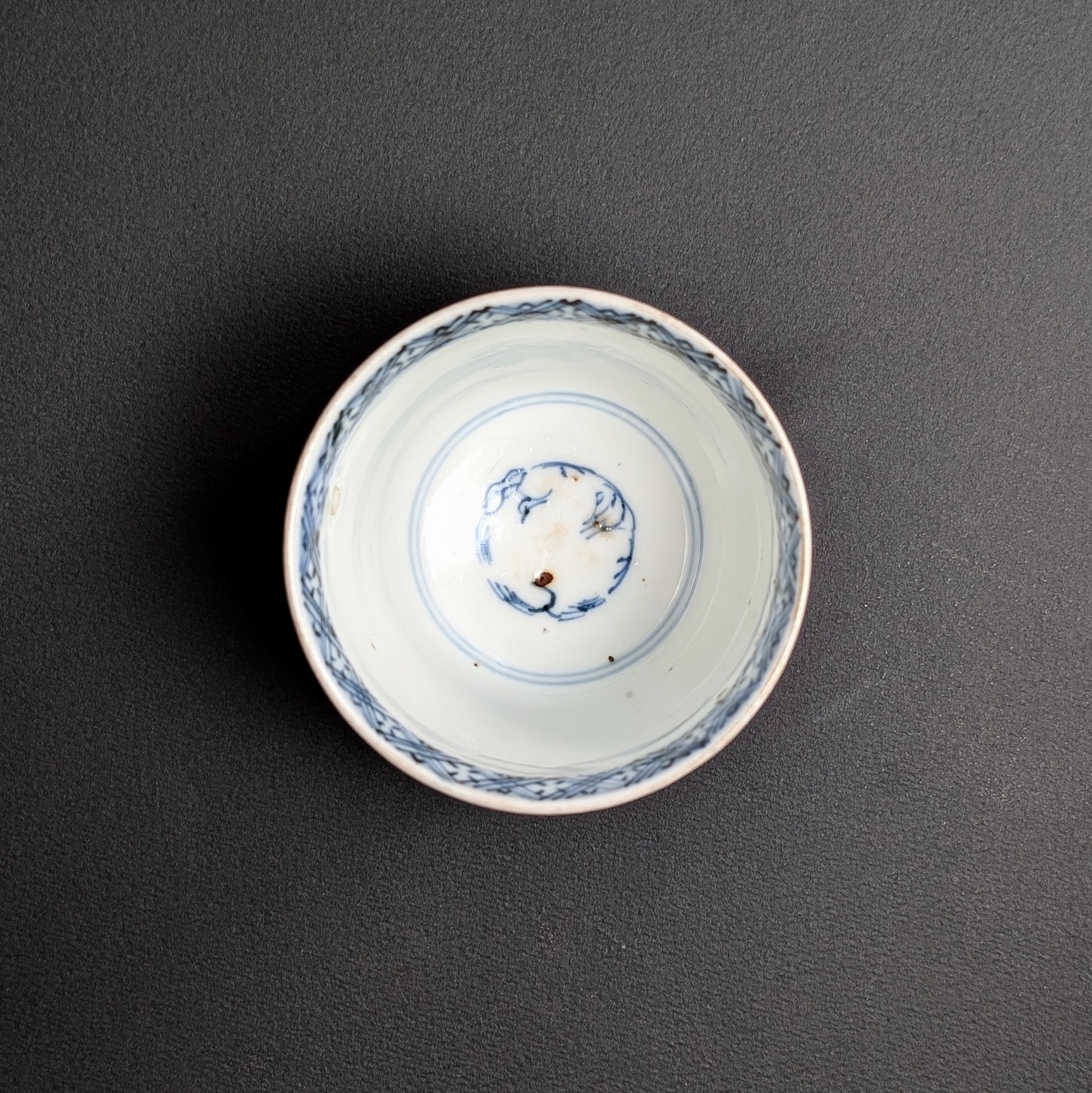 Vue intérieure de tasse à thé japonaise ancienne, décor bleu sometsuke au fond et frise au bord.
