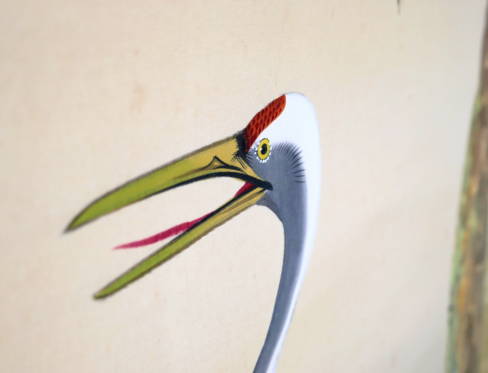 Gros plan sur la tête d’une grue à couronne rouge, peinte à la main sur soie dans ce rouleau suspendu japonais.