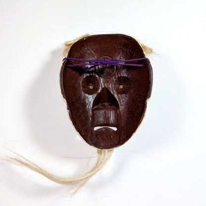 Intérieur d’un masque Nô japonais avec texture bois sculpté et fixation en corde violette, usage scénique traditionnel.