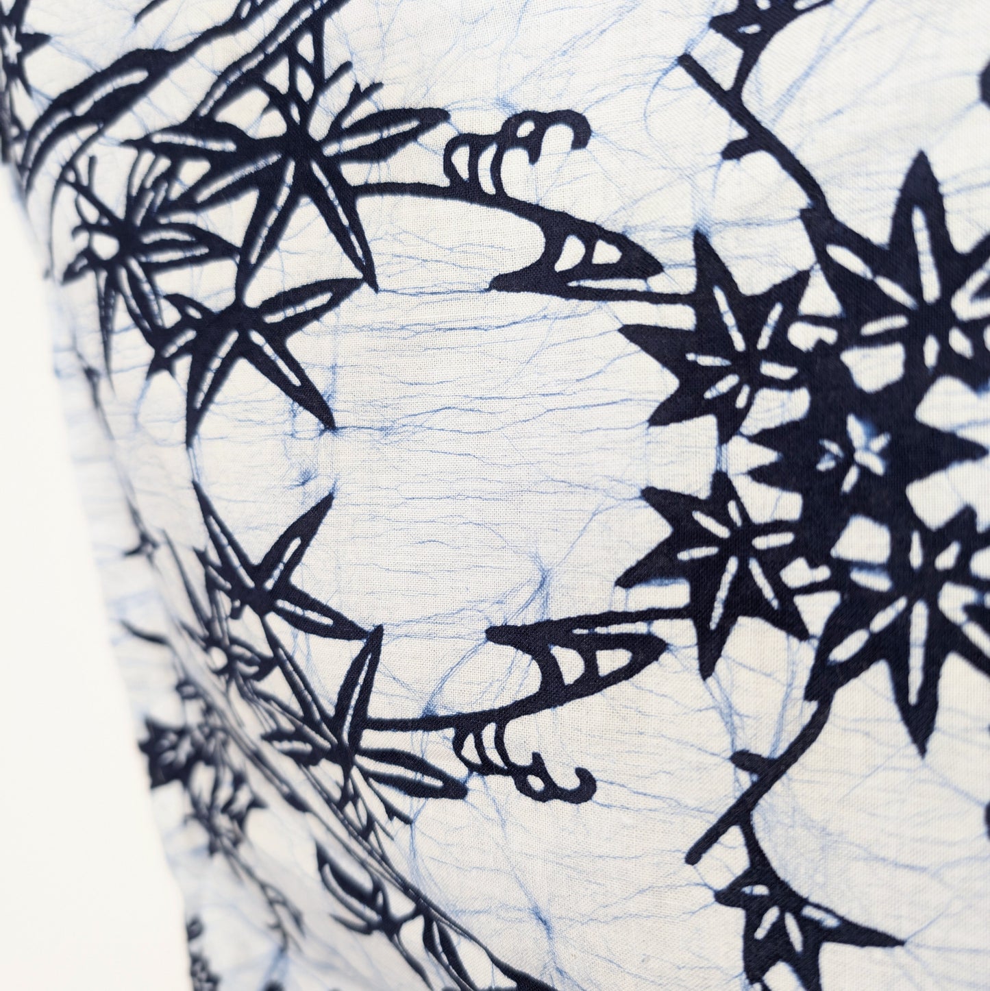 Gros plan du tissu d’un yukata japonais blanc avec motifs bleu indigo de bambou sasa, momiji et fleurs