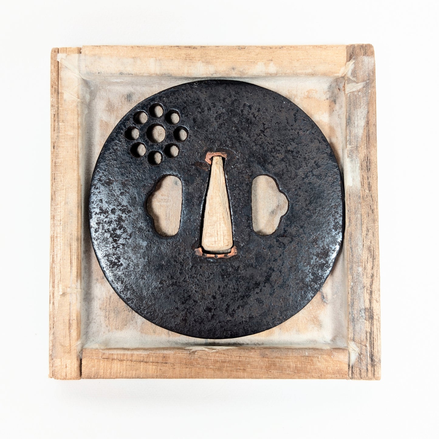 Tsuba antique japonaise Ko-Tōshō présentée dans sa boîte en bois, ancienne garde de sabre en fer à motif Kuyō.