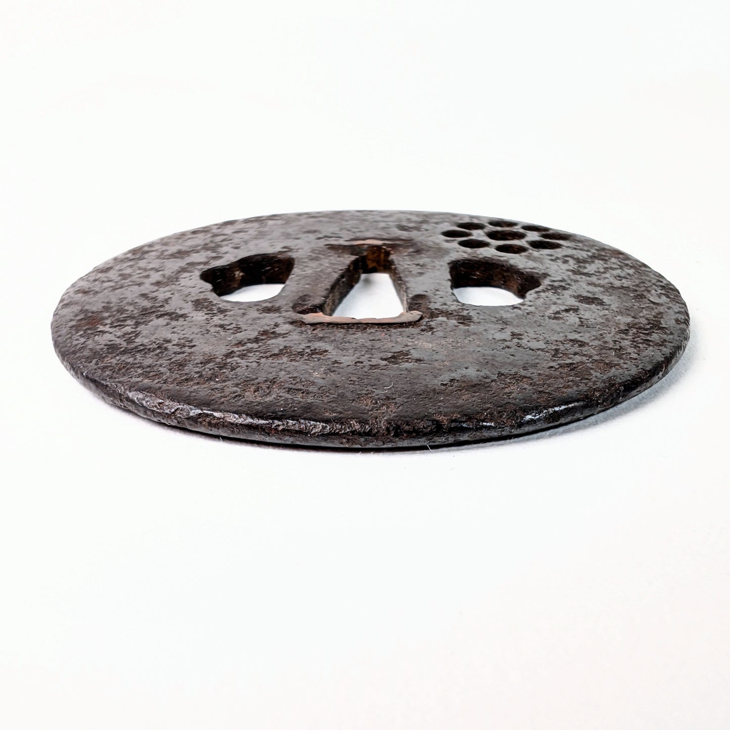 Vue générale d’une tsuba japonaise ancienne Ko-Tōshō en fer, de forme marugata, ornée d’un Kuyō-mon en sukashi.