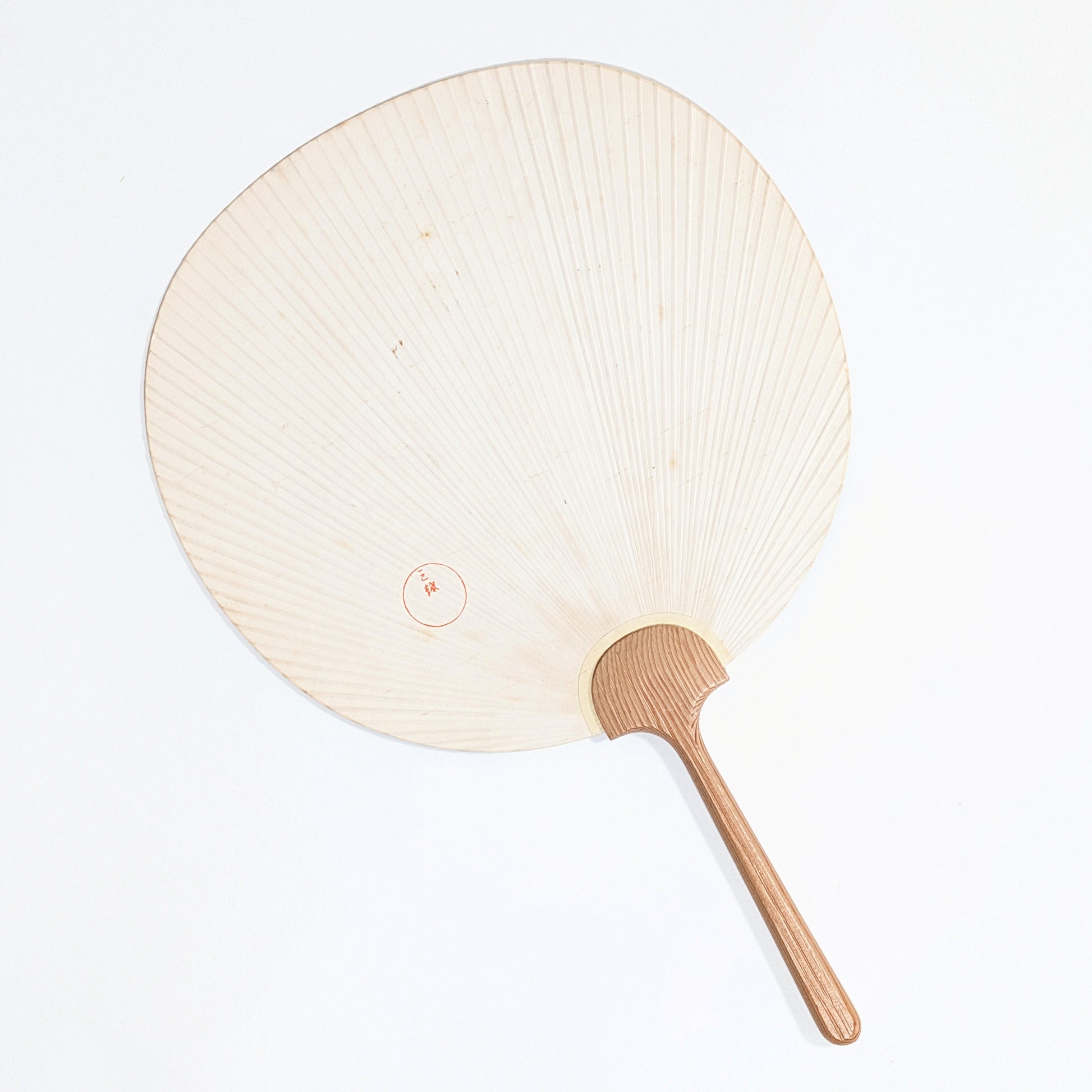 Dos d’un éventail uchiwa japonais Mitsukoshi avec sceau rouge 三越, structure rayonnante et manche en bois