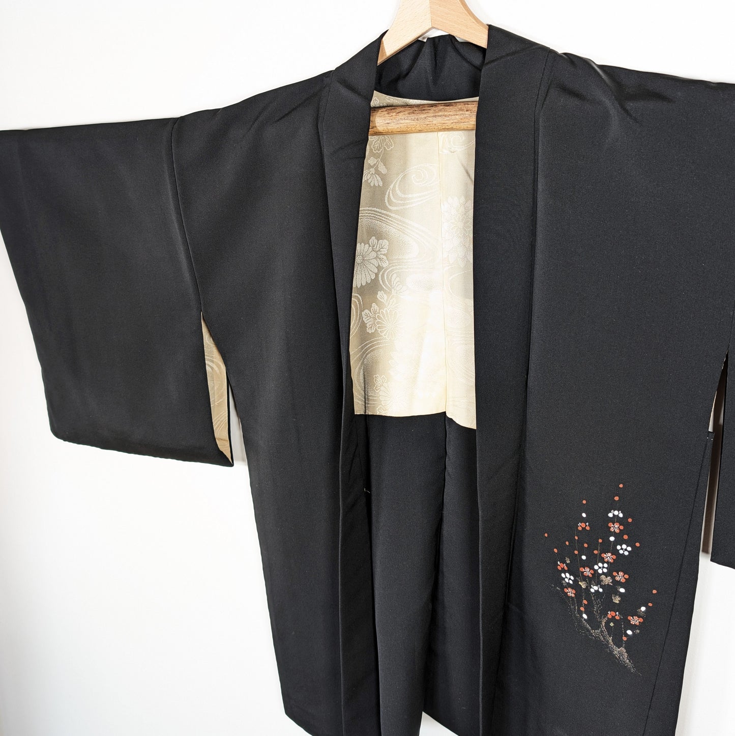 Haori en soie noire habutae, veste japonaise femme avec brillance discrète, doublure ivoire et motif ume sur le pan avant.