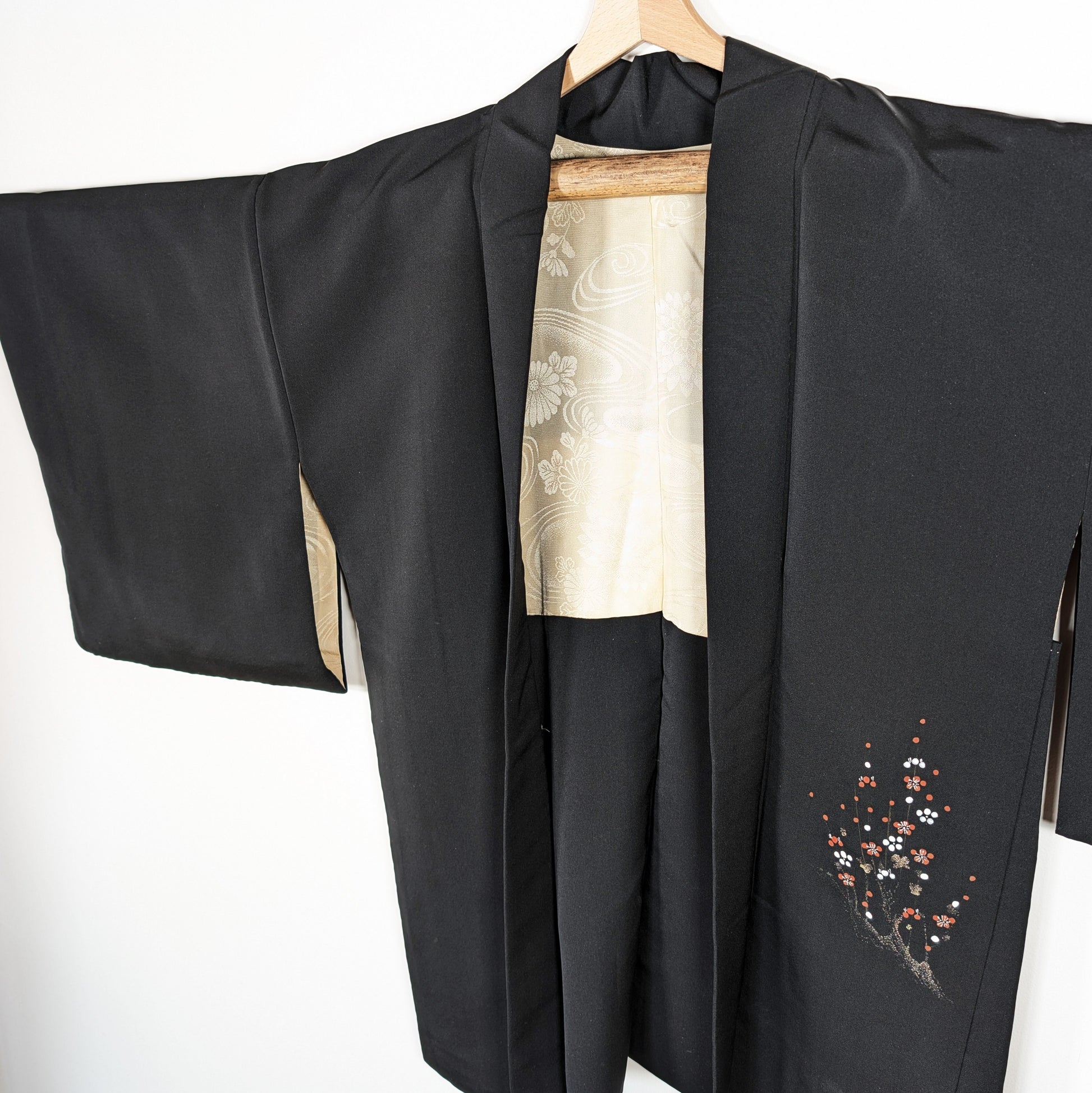 Haori en soie noire habutae, veste japonaise femme avec brillance discrète, doublure ivoire et motif ume sur le pan avant.
