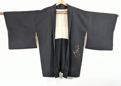 Veste kimono japonaise traditionnelle en soie noire shōken, décor floral ume sur le pan avant et doublure ivoire à motifs japonais.
