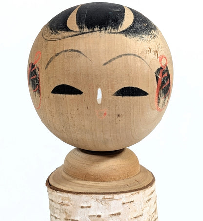 Visage peint à la main d’une kokeshi japonaise style Shōwa – artisanat japonais traditionnel.