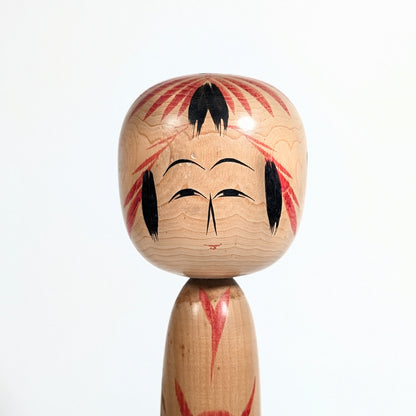 Détail du visage d’une kokeshi japonaise Togatta avec motif Tegara peint à la main par Sato Tomio