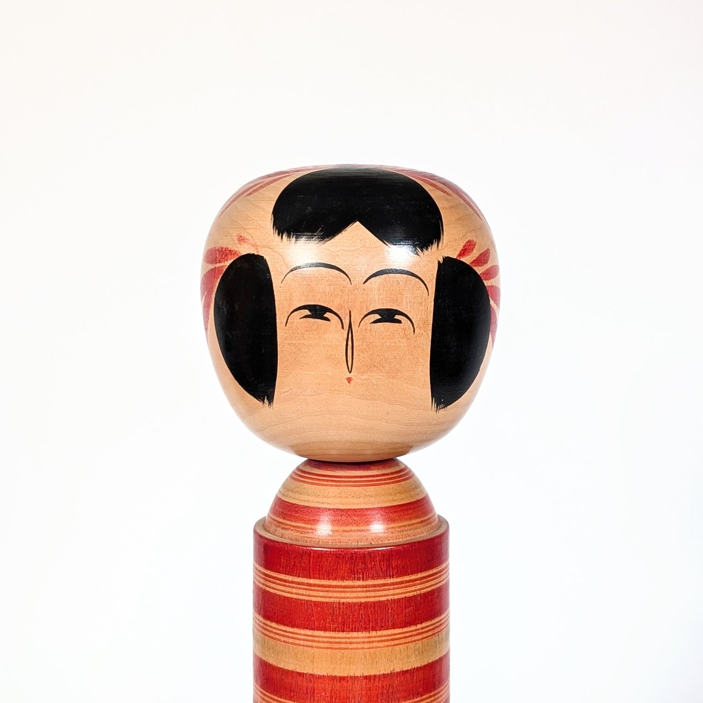 Visage peint d’une kokeshi Sakunami Hiraga Tadashi, expression minimaliste traditionnelle japonaise