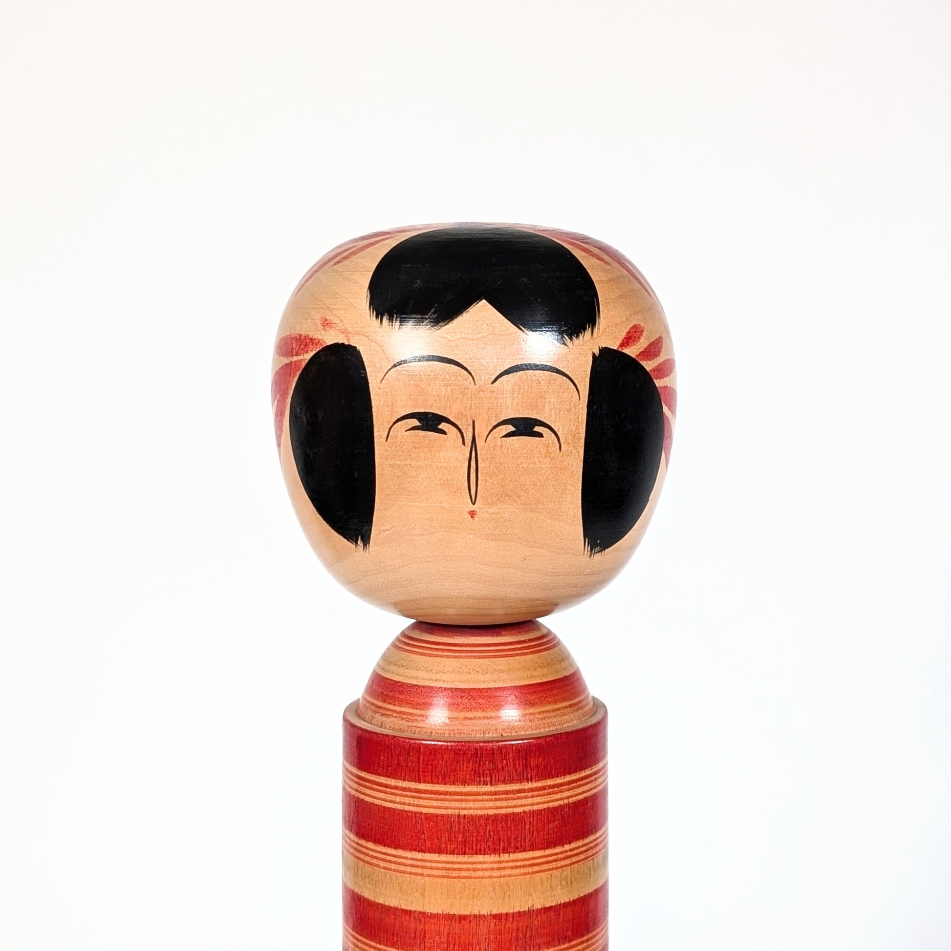 Visage peint d’une kokeshi Sakunami Hiraga Tadashi, expression minimaliste traditionnelle japonaise