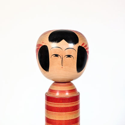 Visage peint d’une kokeshi Sakunami Hiraga Tadashi, expression minimaliste traditionnelle japonaise