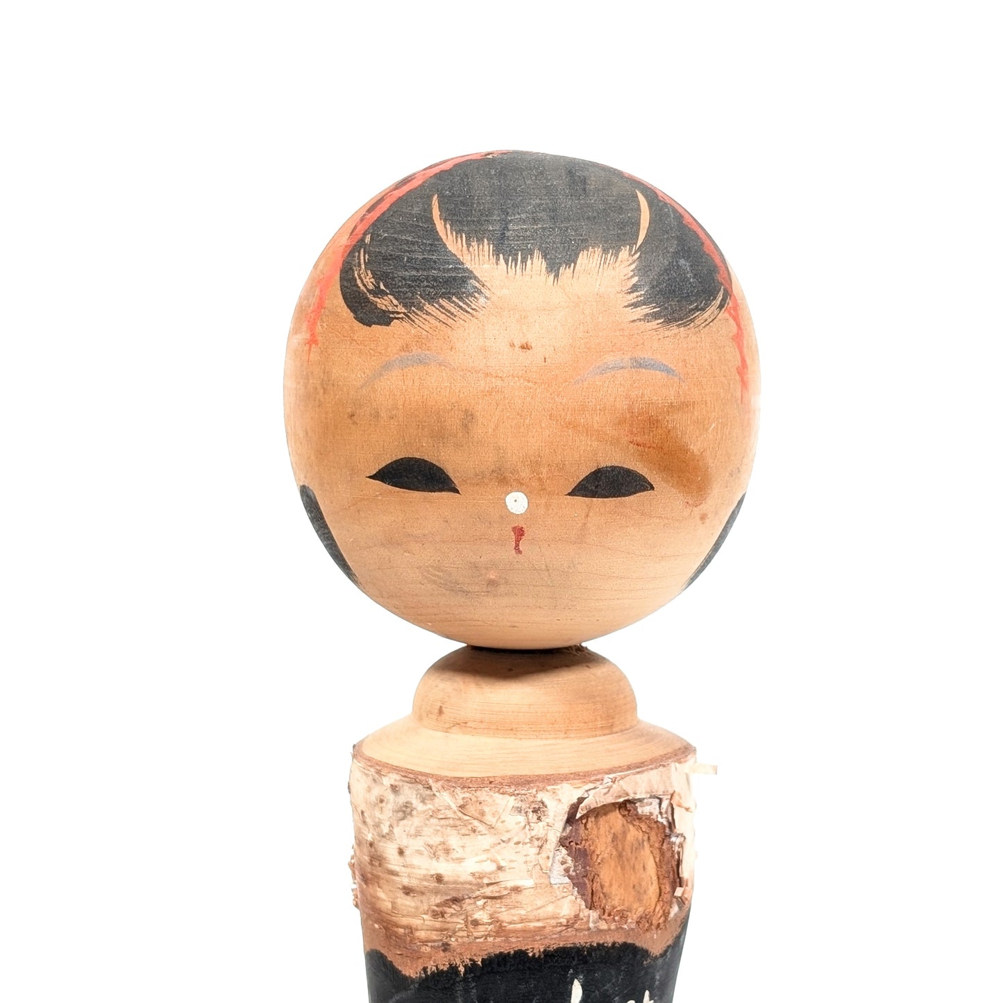 Gros plan du visage d’une kokeshi Zao Onsen vintage, coiffure noire et détails rouges peints à la main
