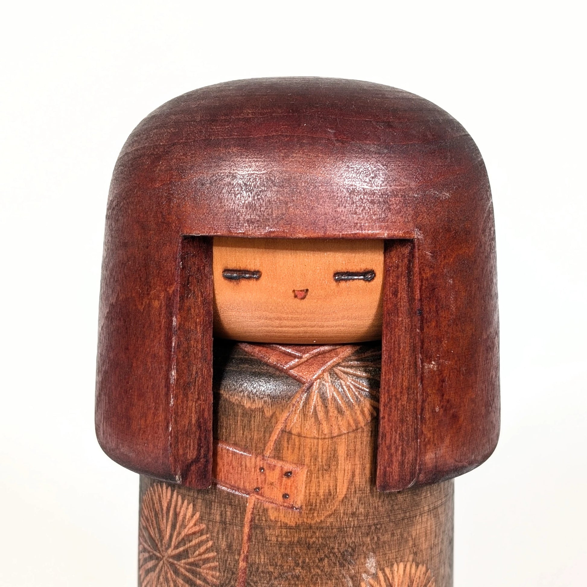Visage d’une poupée japonaise kokeshi sōsaku, expression minimaliste sculptée en bois par Sansaku Sekiguchi