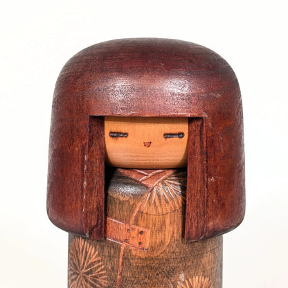Visage d’une poupée japonaise kokeshi sōsaku, expression minimaliste sculptée en bois par Sansaku Sekiguchi