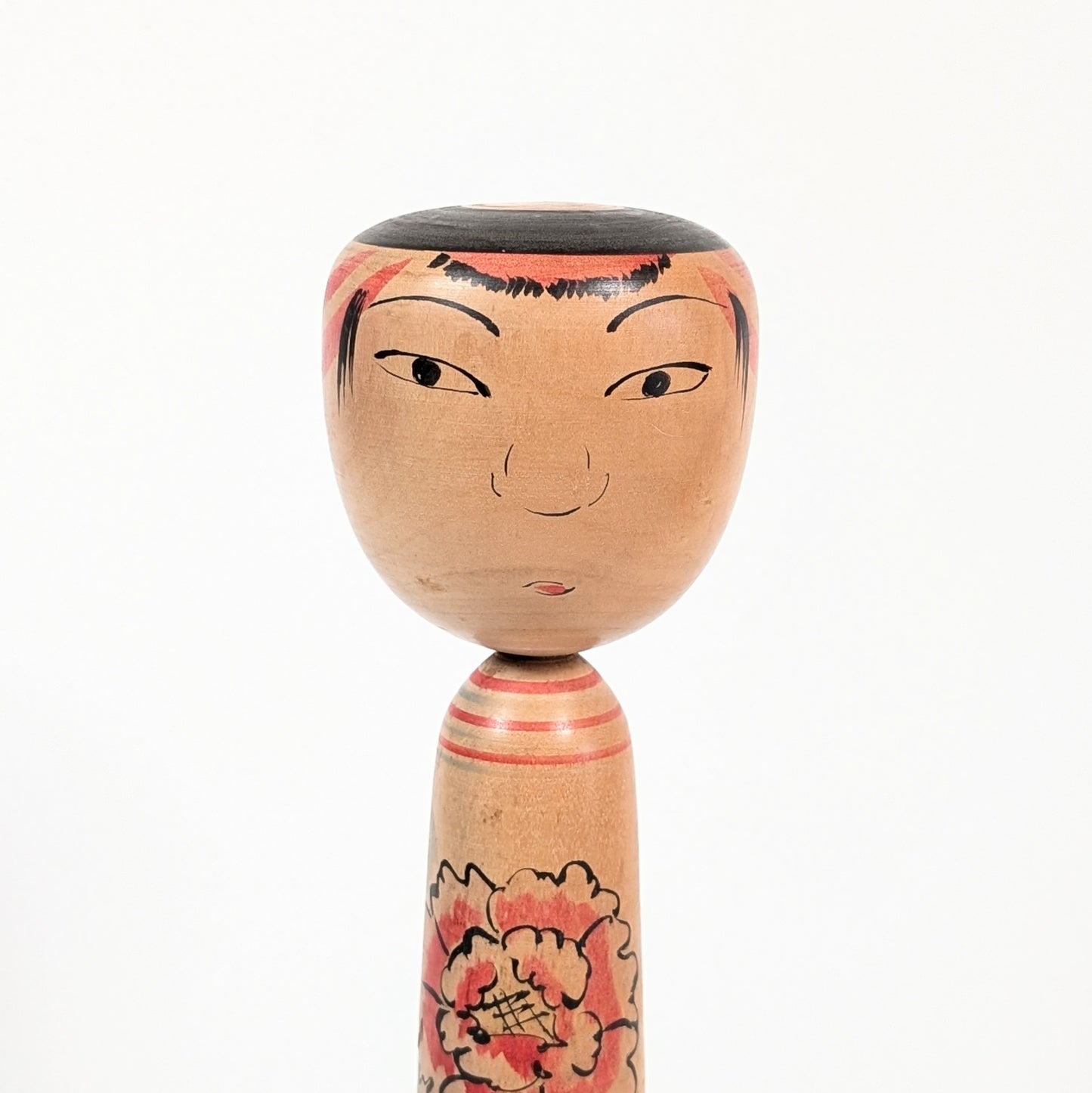Détail du visage d’une poupée kokeshi Nakanosawa par Arakawa Yōichi, regard doux et expressif.