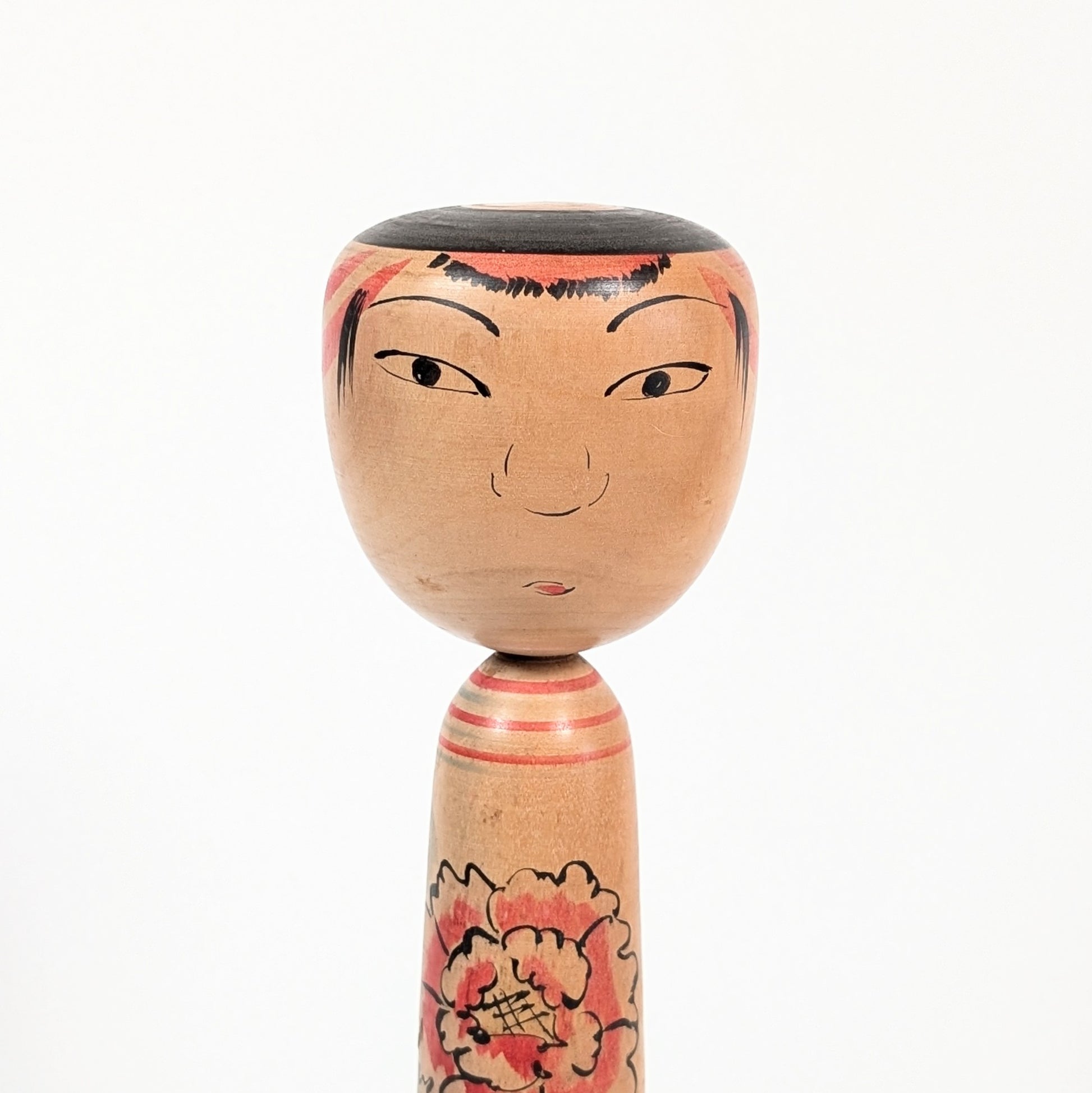 Détail du visage d’une poupée kokeshi Nakanosawa par Arakawa Yōichi, regard doux et expressif.
