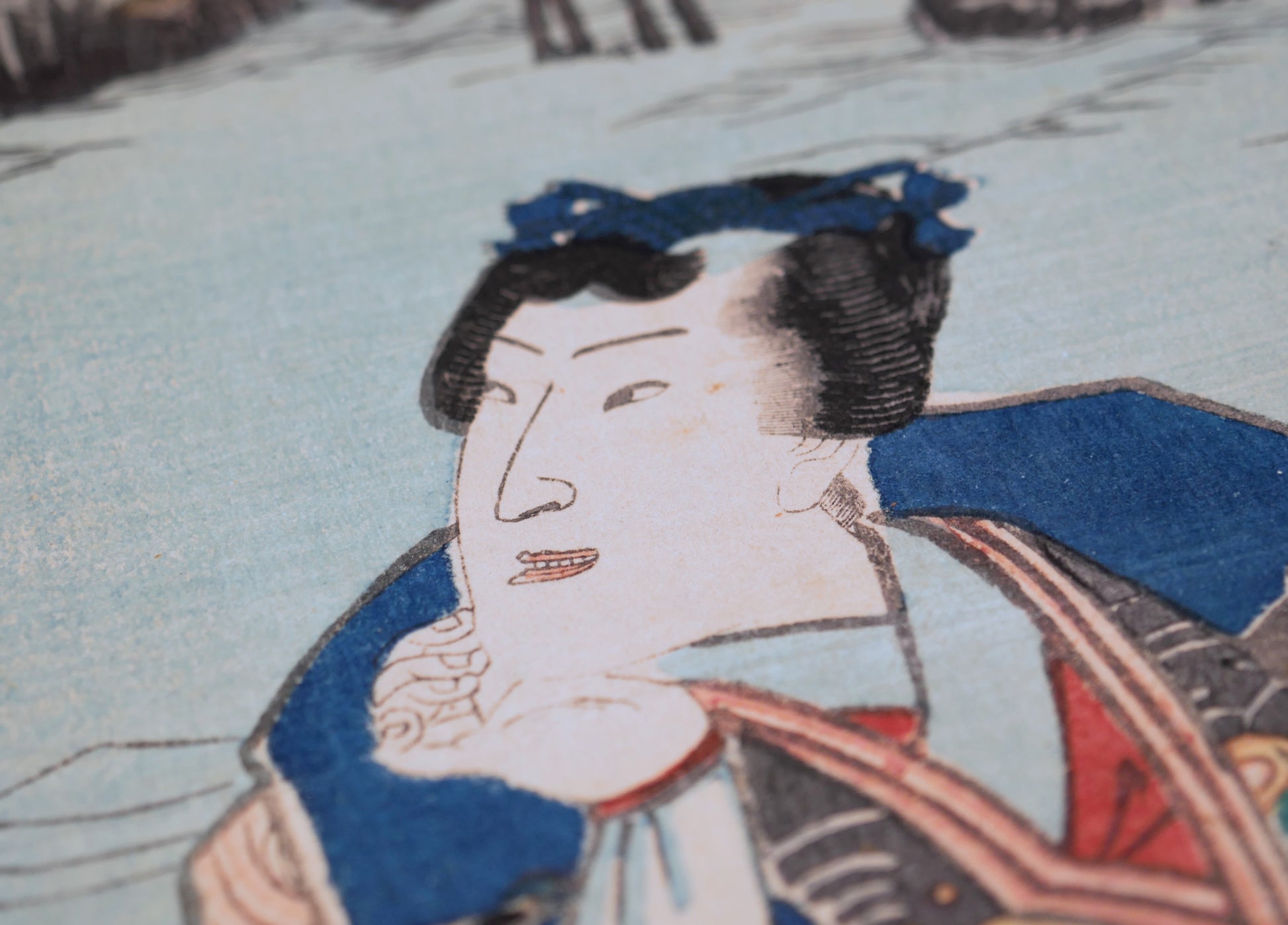 Gros plan du visage d’un samouraï au chonmage dans une gravure sur bois japonaise de Kunisada