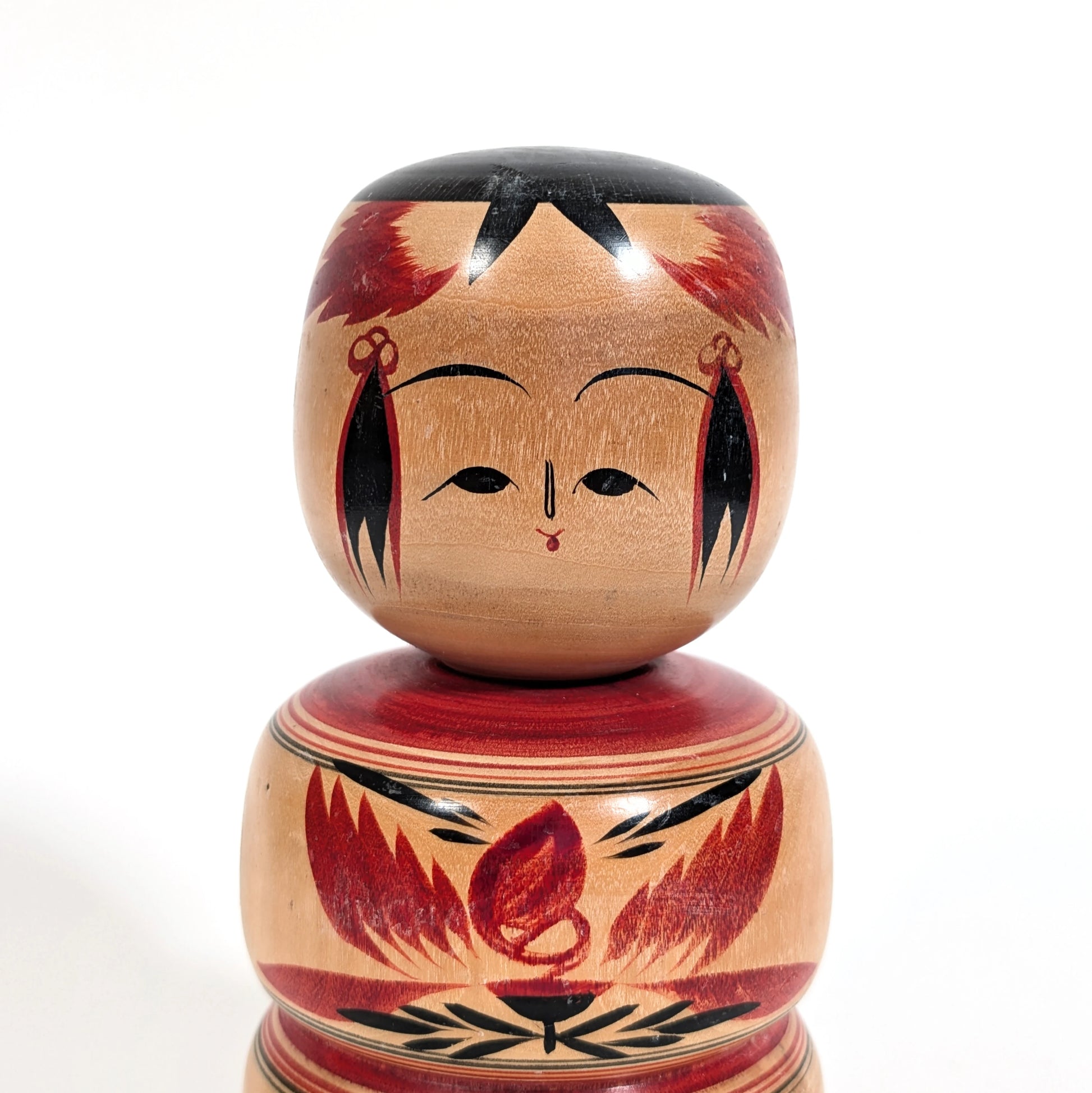 Visage peint à la main d’une poupée kokeshi japonaise traditionnelle