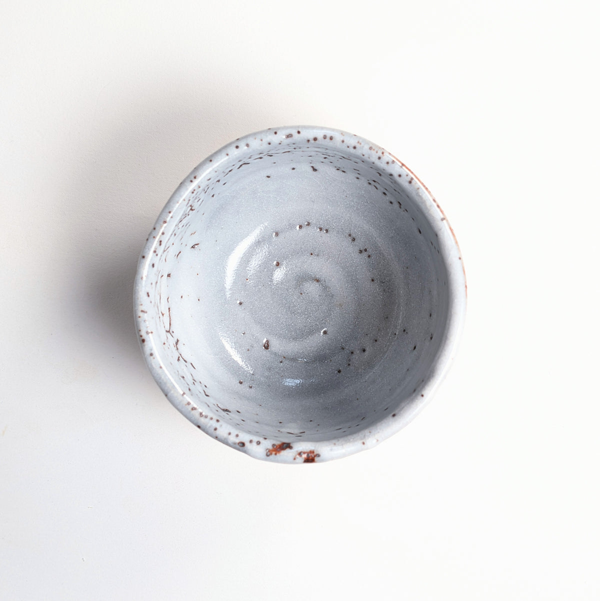 Vue de dessus du bol à matcha japonais Shino montrant son intérieur gris bleuté moucheté et sa forme irrégulière.