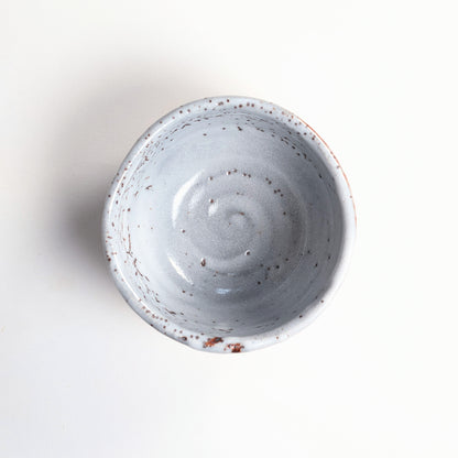 Vue de dessus du bol à matcha japonais Shino montrant son intérieur gris bleuté moucheté et sa forme irrégulière.