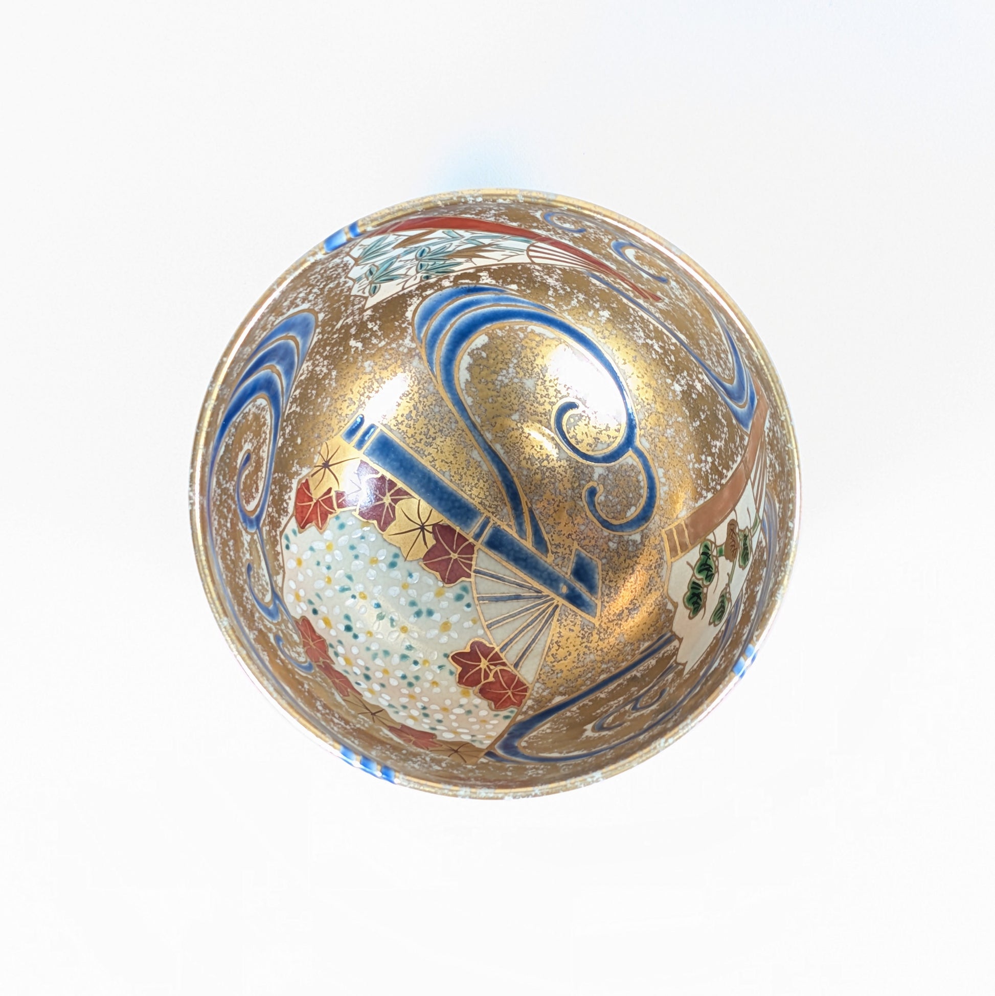 Vue plongeante du mikomi du chawan, entièrement décoré d’éventails senmen-nagashi, de vagues bleues et d’or moucheté.