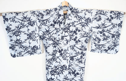 Yukata japonais authentique présenté manches déployées, fond blanc et décor bleu indigo de feuilles et fleurs