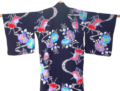 Dos d’un yukata bleu marine à fleurs multicolores typique de l’été japonais.