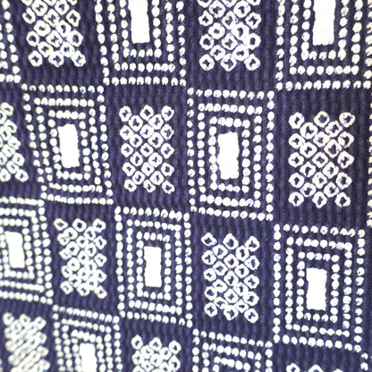 Zoom sur le motif géométrique du yukata, inspiré du style shibori sur fond bleu foncé.