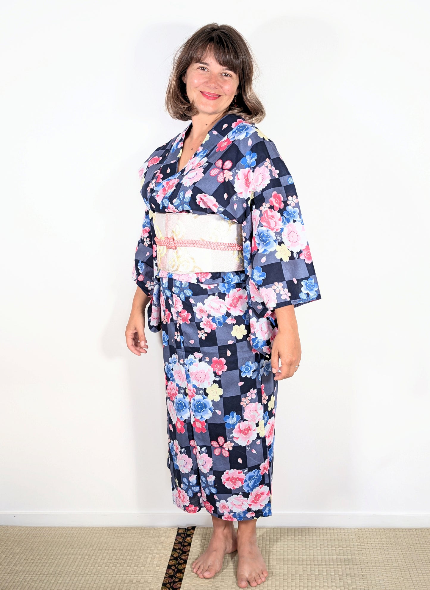 Yukata japonais femme en coton avec motif sakura sur damier ichimatsu gris et noir, porté avec obi clair